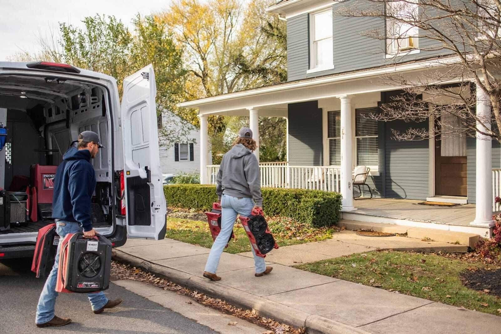Water damage restoration crew arriving at a residential home with professional equipment